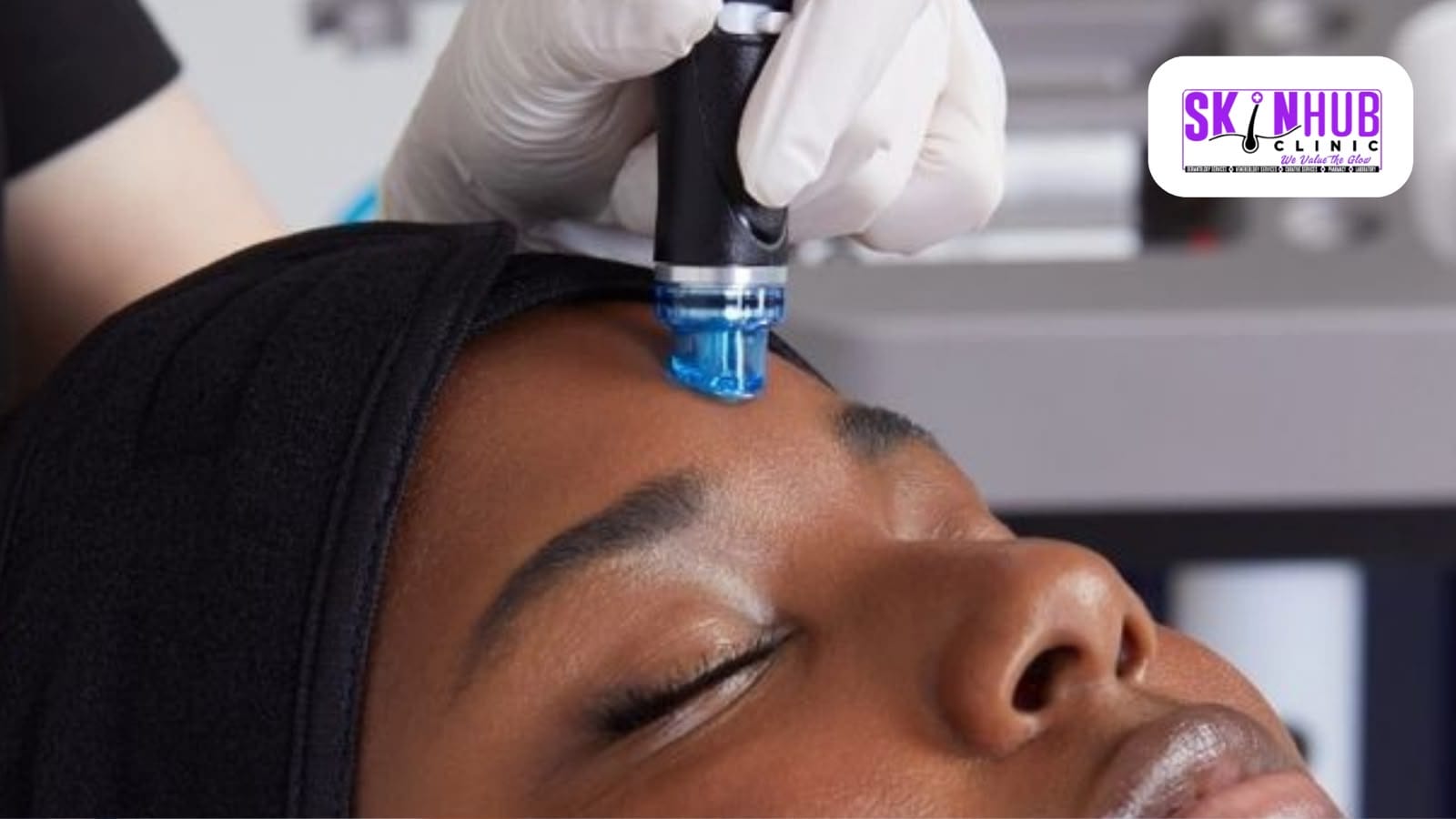 A hydrafacial handpiece gliding across a patient’s forehead during a treatment session